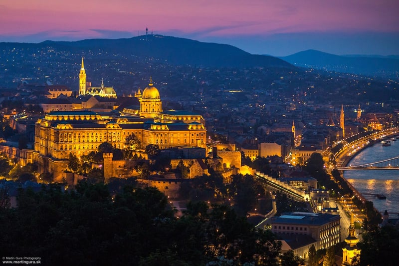 Budapeštiansky parlament a most cez Dunaj nasvietené v modrej hodine.