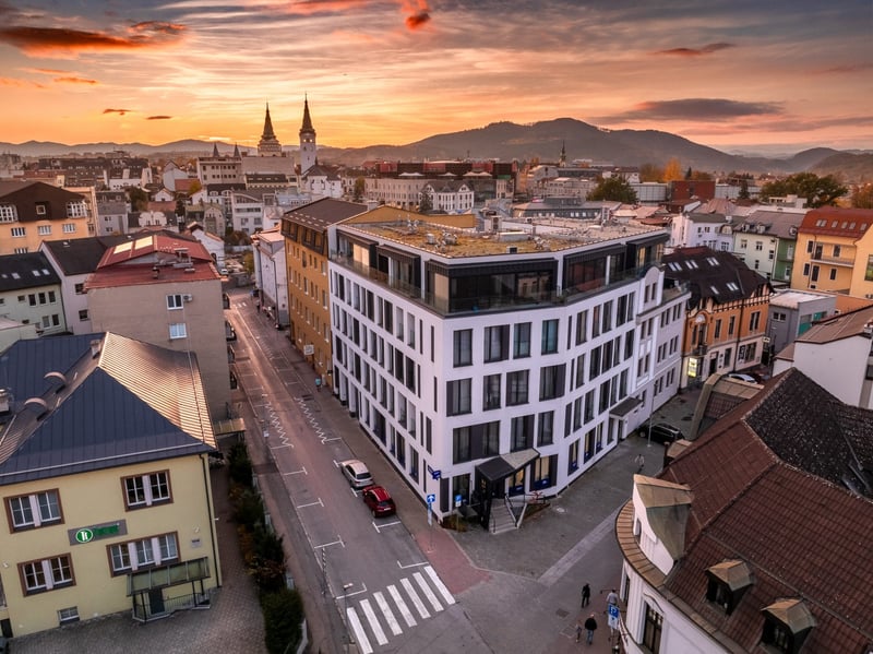 Letecký pohľad z dronu na moderný bytový dom v centre Žiliny pri západe slnka.