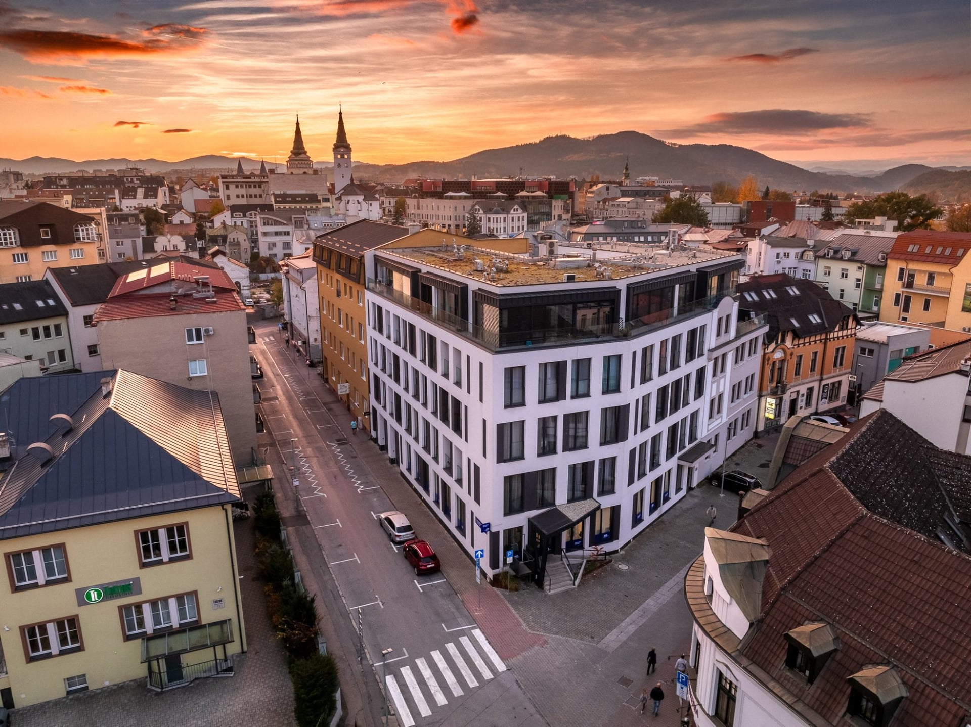 Letecký pohľad z dronu na moderný bytový dom v centre Žiliny pri západe slnka