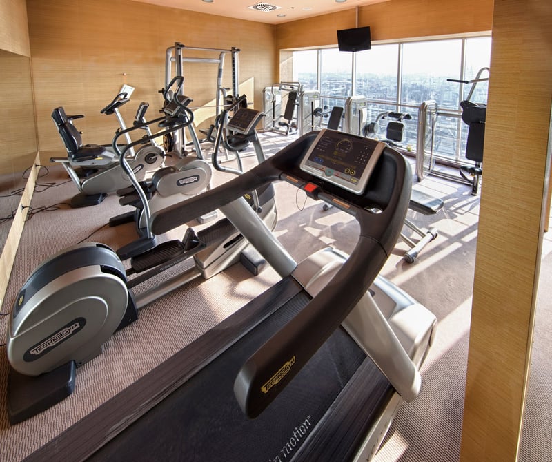 Hotelová posilňovňa vybavená strojmi TechnoGym s veľkými oknami.