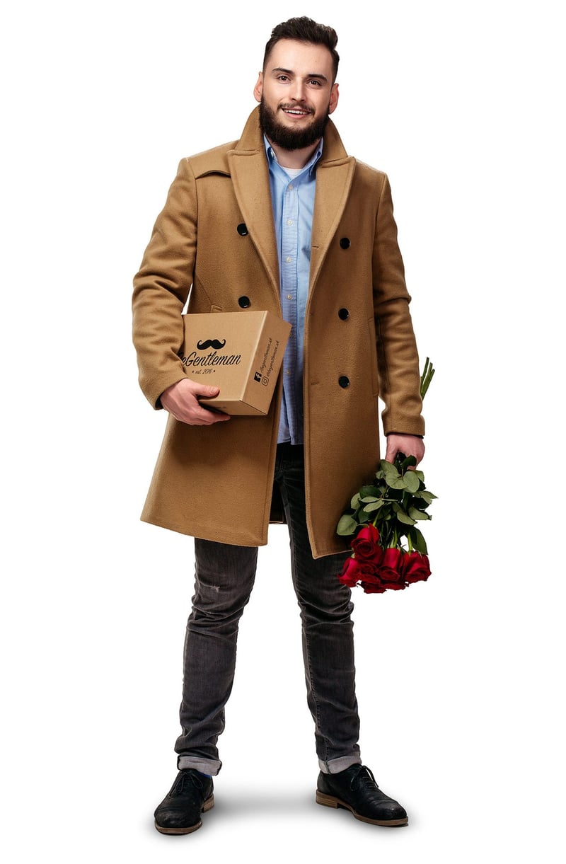 Reklamný portrét mladíka v béžovom kabáte s krabicou MGentleman a kyticou červených ruží.