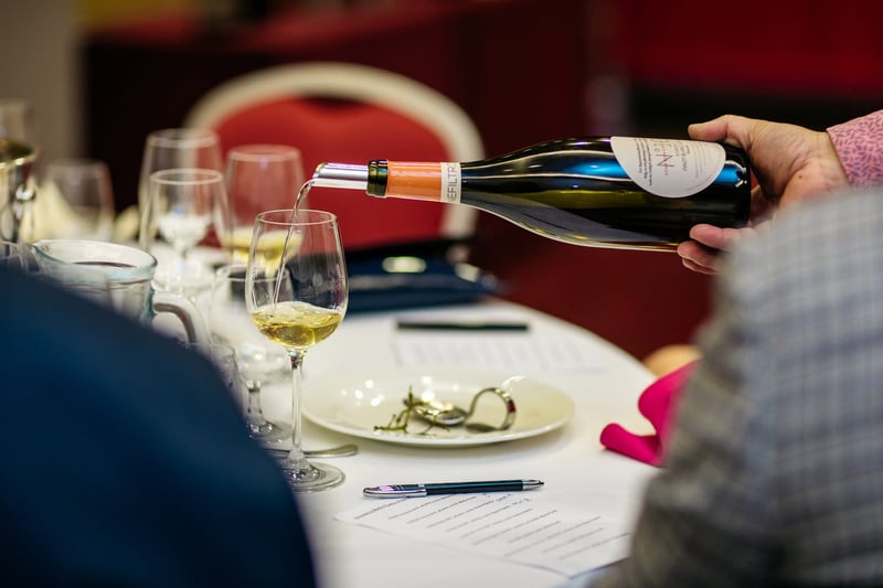Sommelier nalieva biele víno do degustačného pohára počas degustácie