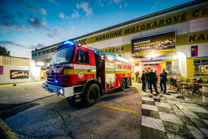 Hasičské vozidlo pred budovou motokárového centra počas večernej akcie