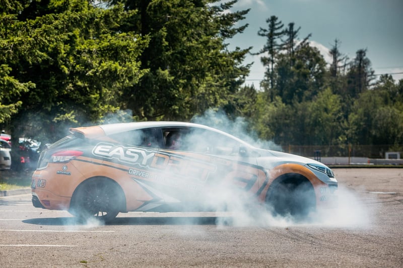 Drift auto v zákrute s dymom z pneumatík počas driving eventu