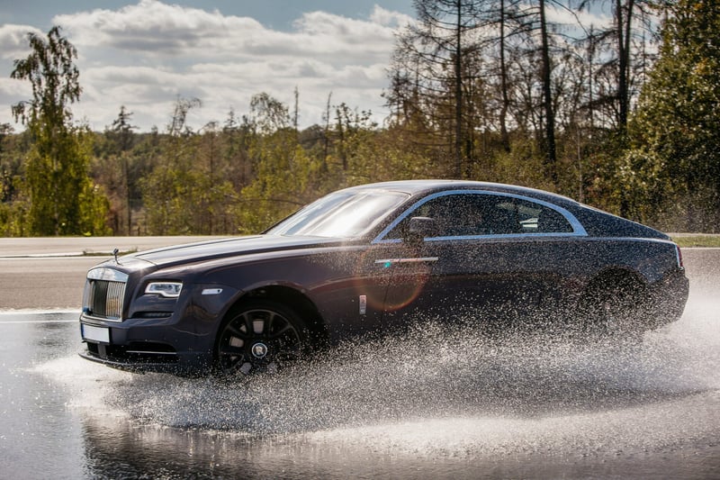 Luxusné coupe auto v zákrute na mokrom okruhu počas driving experience