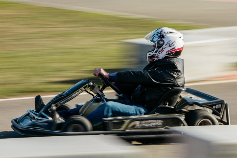 Pretekár v go-karte v plnej rýchlosti na trati, motion blur prostredia