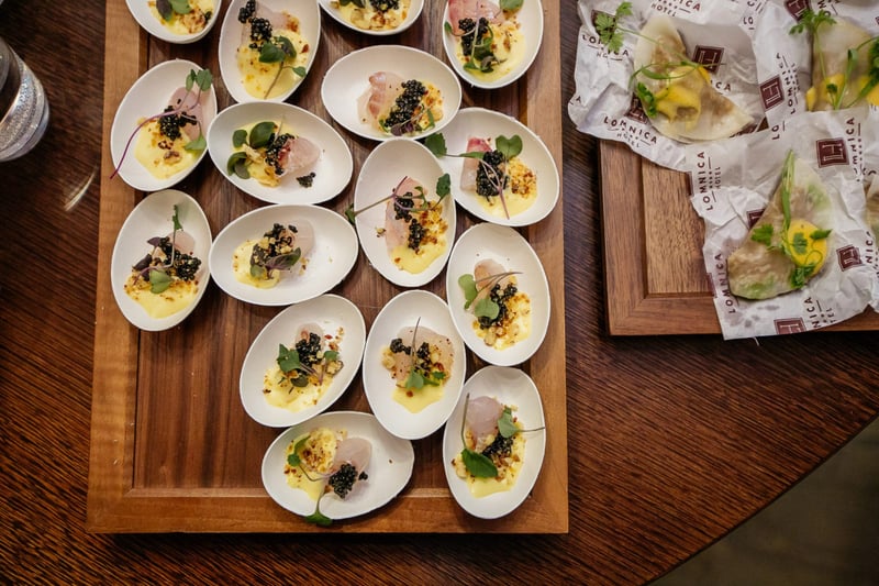 Drevený podnos s elegantne nakomponovanými amuse-bouche kanapkami pripravený na degustáciu