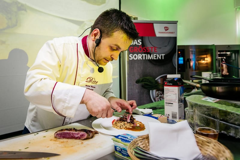 Šéfkuchár s headset mikrofónom finalizuje porciu počas show cookingu